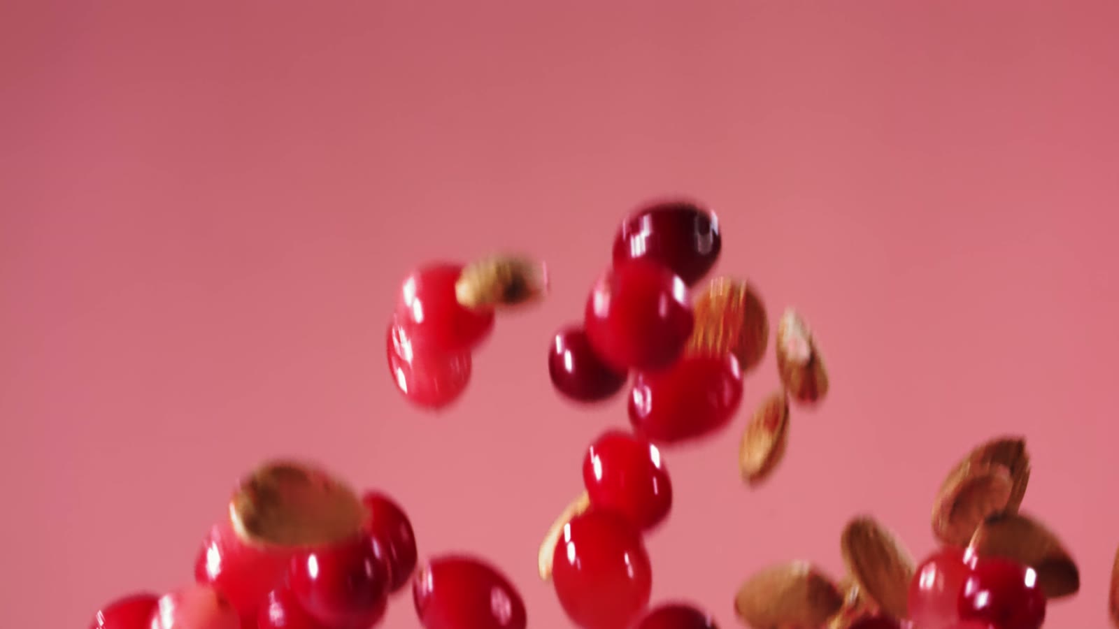廣告影片定格:粉紅色背景前,果乾與堅果在空中落下