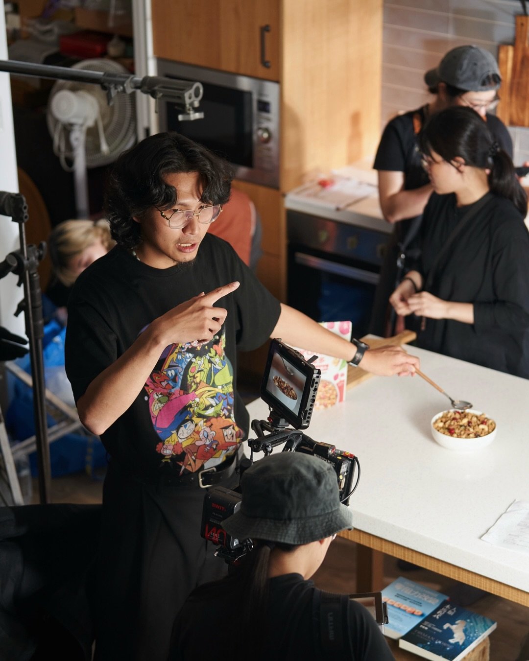 導演在攝影機旁與食物造型團隊討論下一個畫面