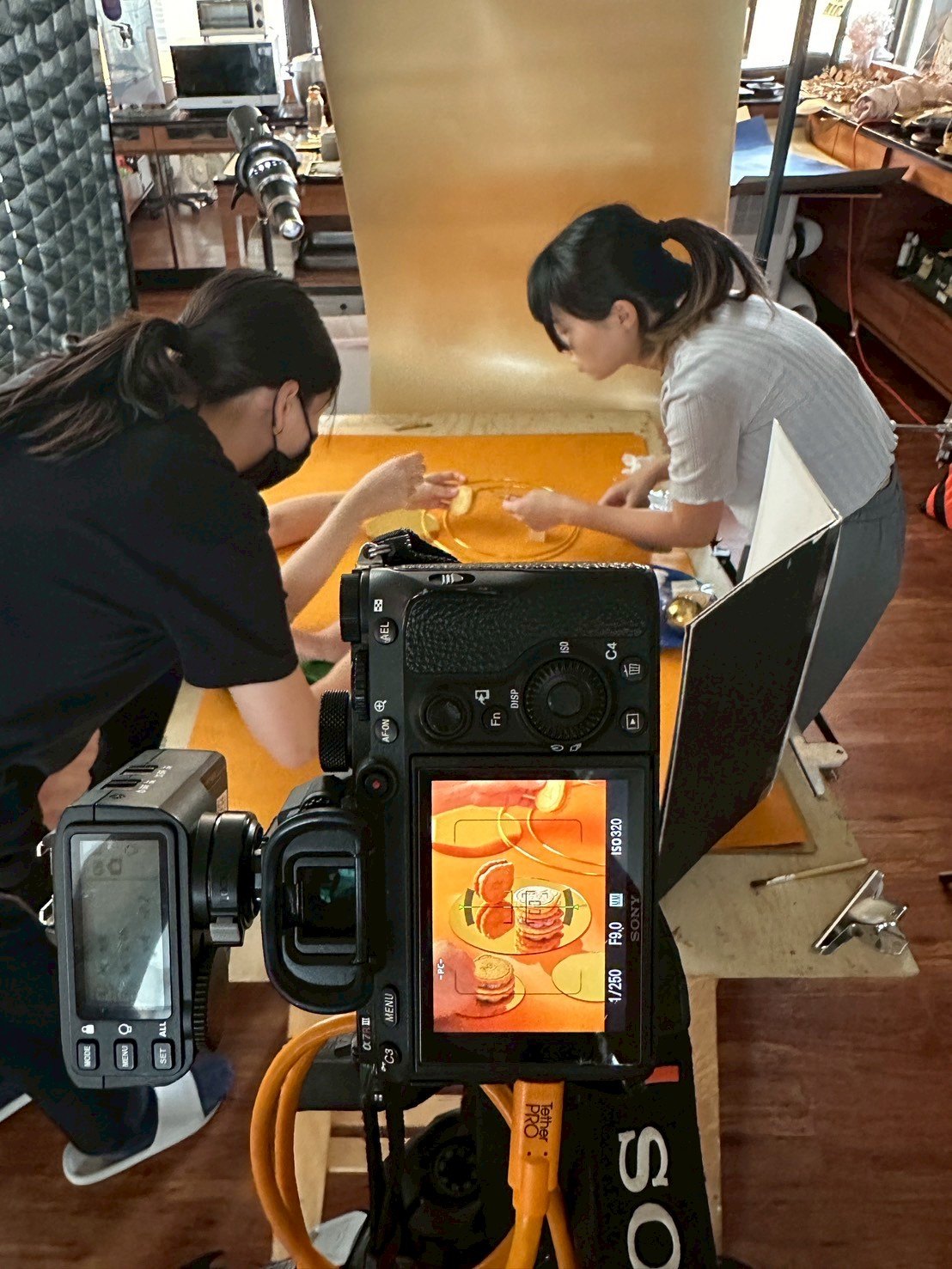 團隊在金色背景與桌面前確認食物位置