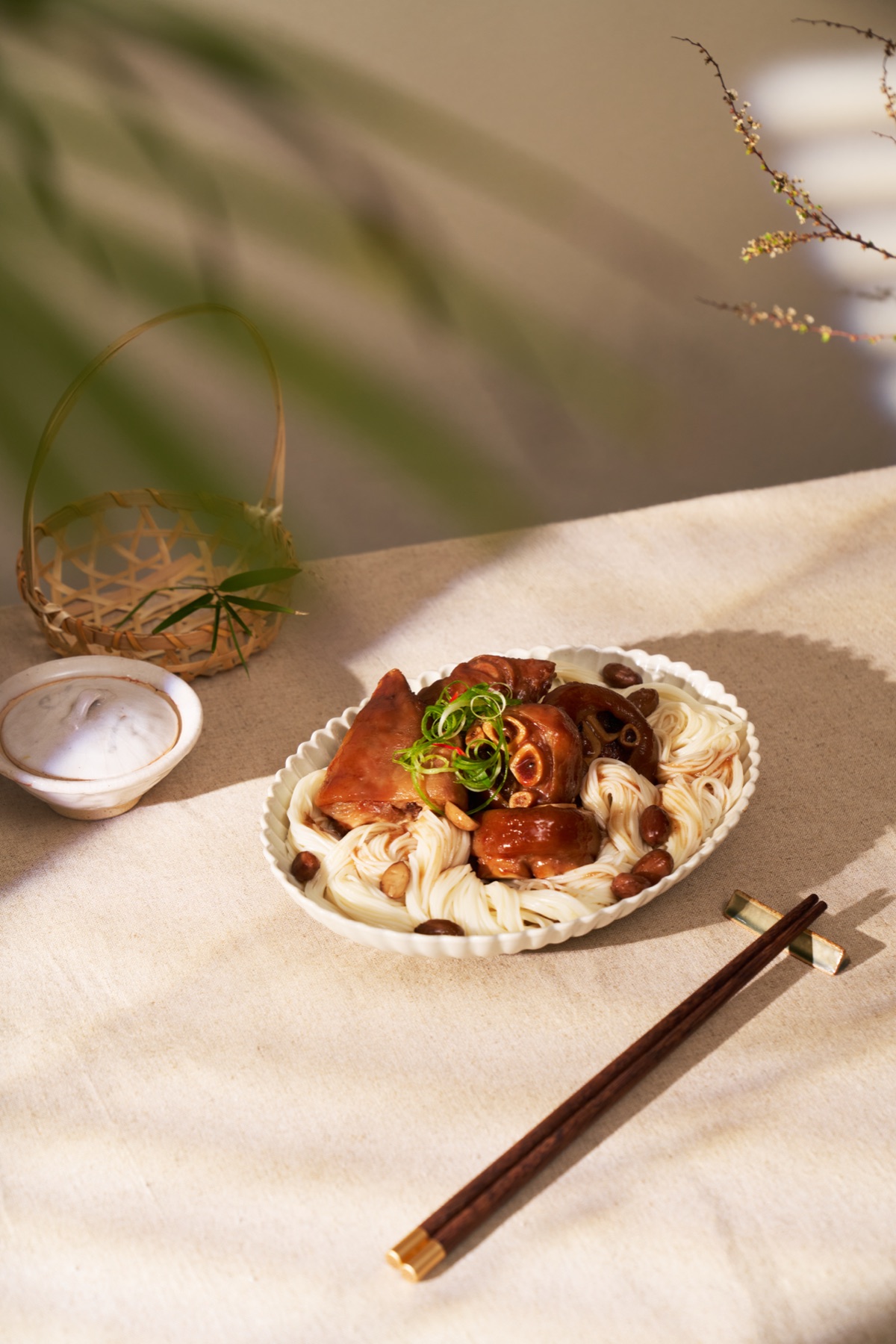 暖色斜光下的滷肉麵線與餐具