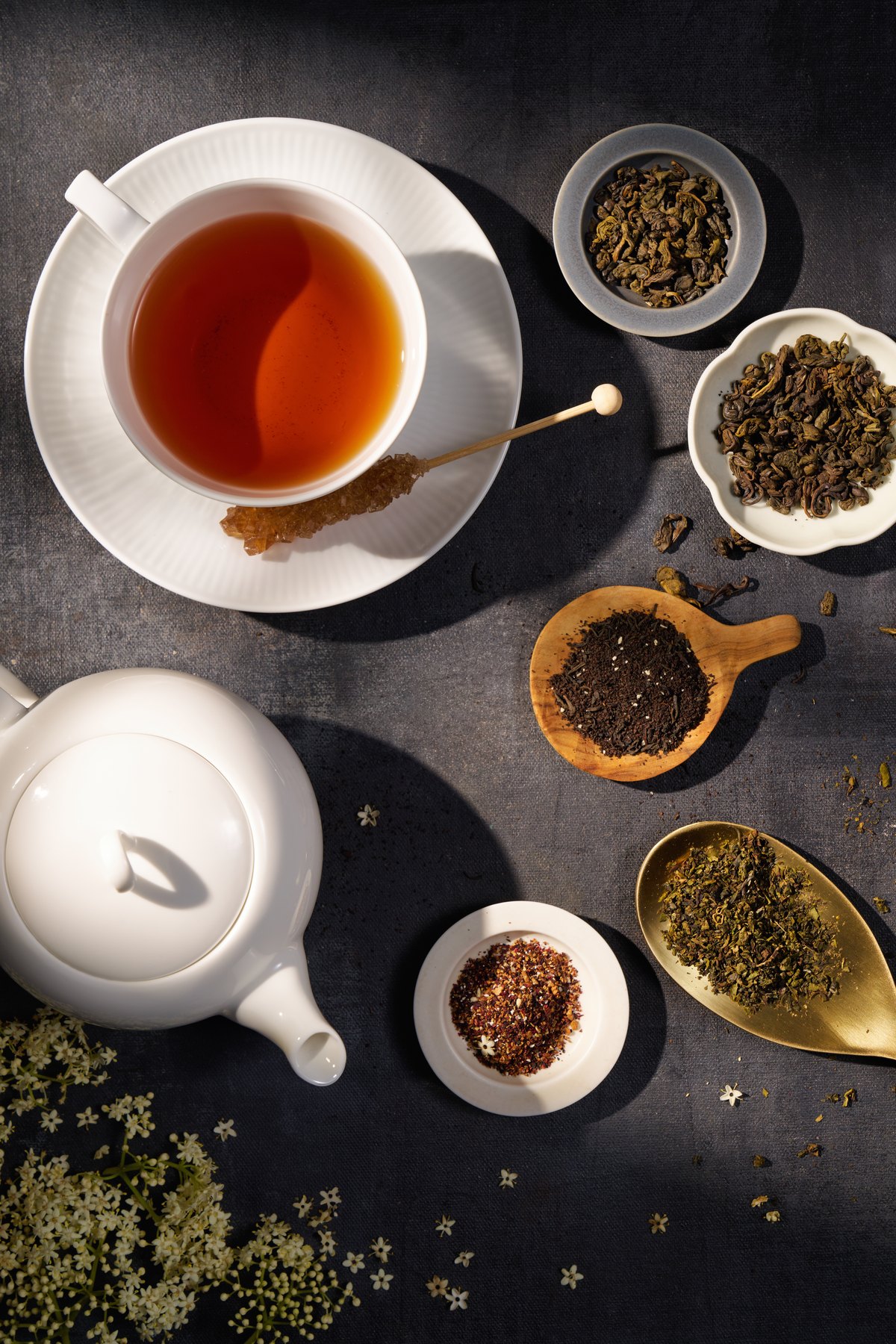 俯視茶杯、茶葉與器皿的深色構圖