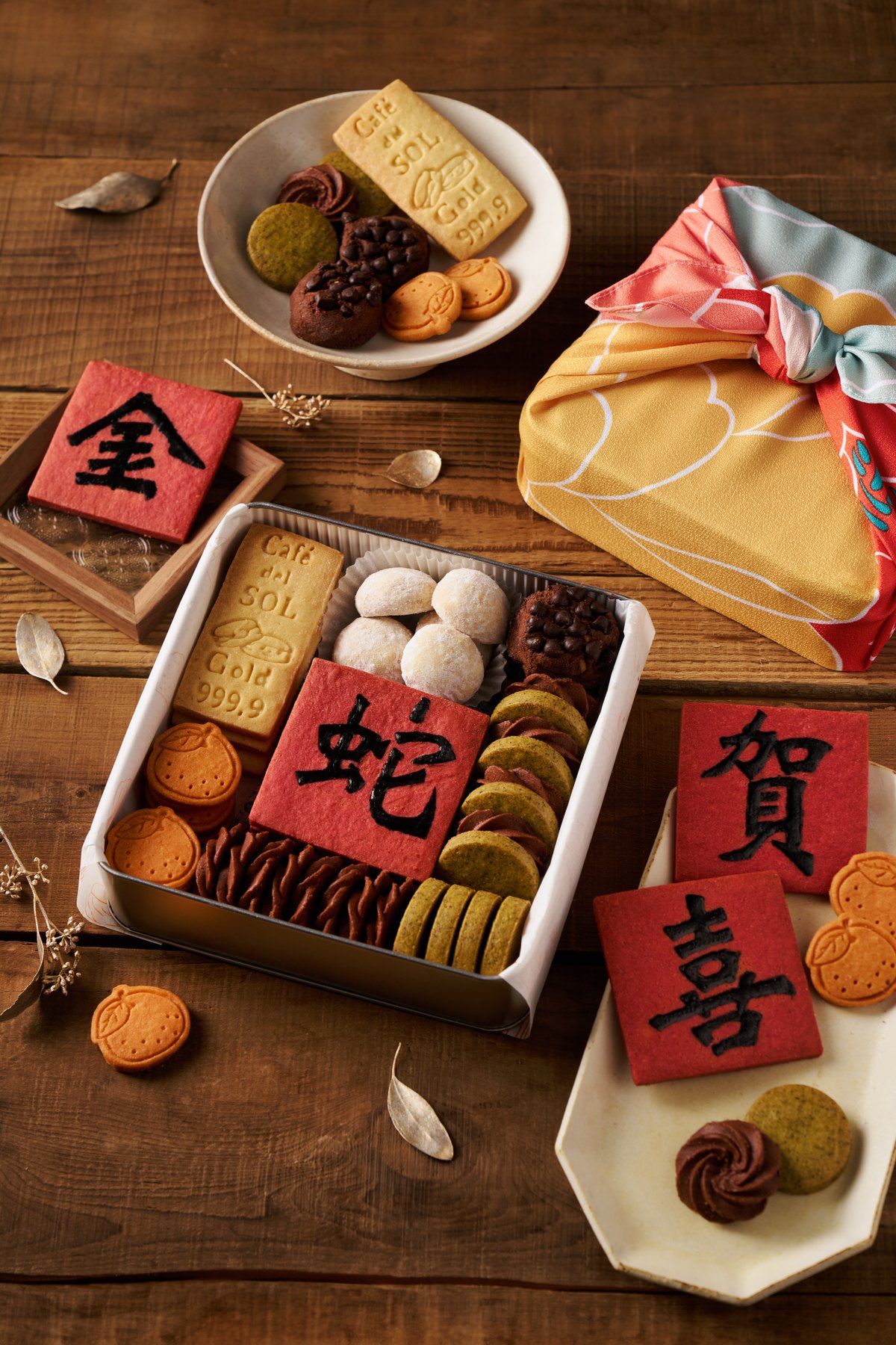 木桌上的新春甜點禮盒與賀年字樣