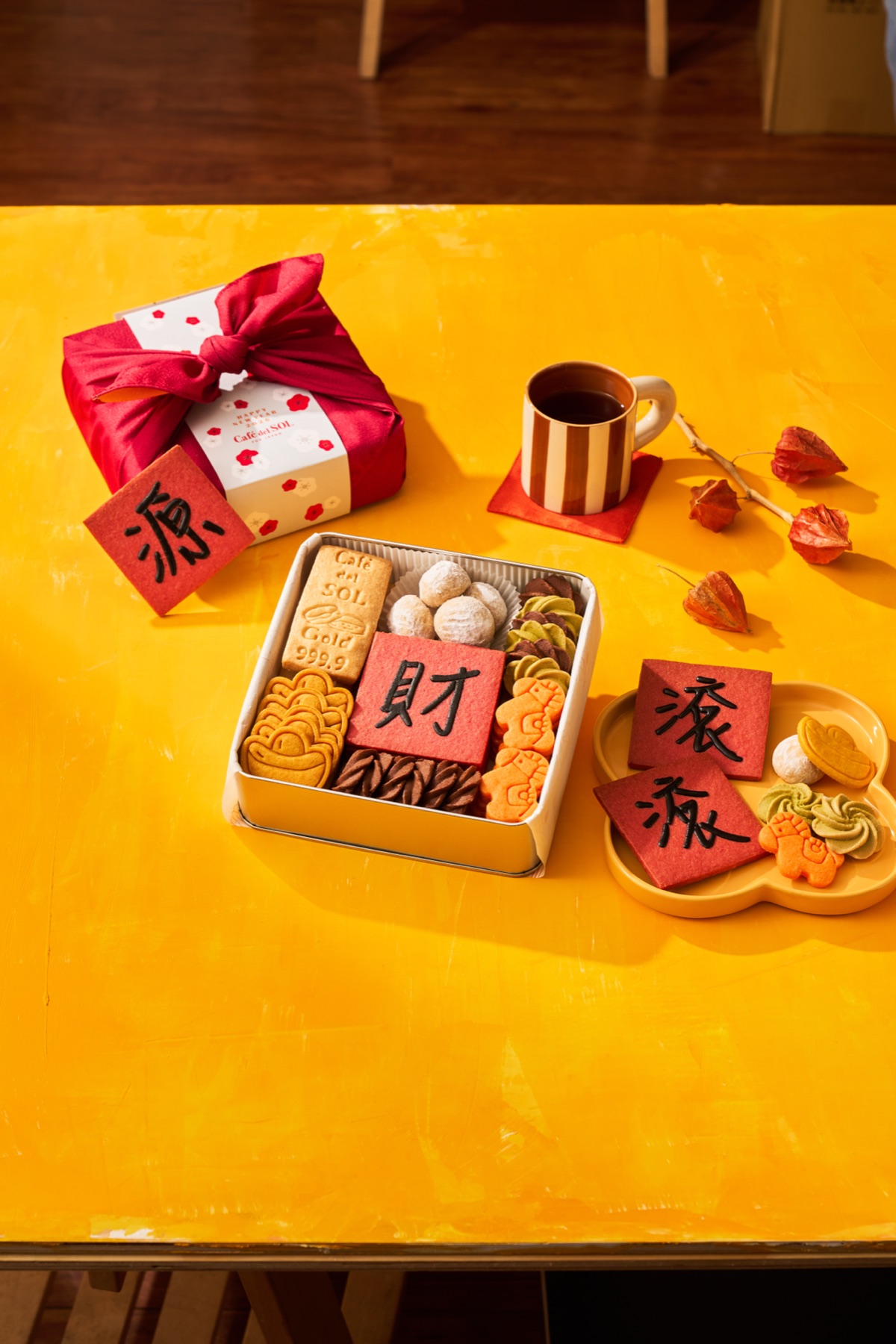 黃色桌面上的餅乾鐵盒、包裝與熱飲