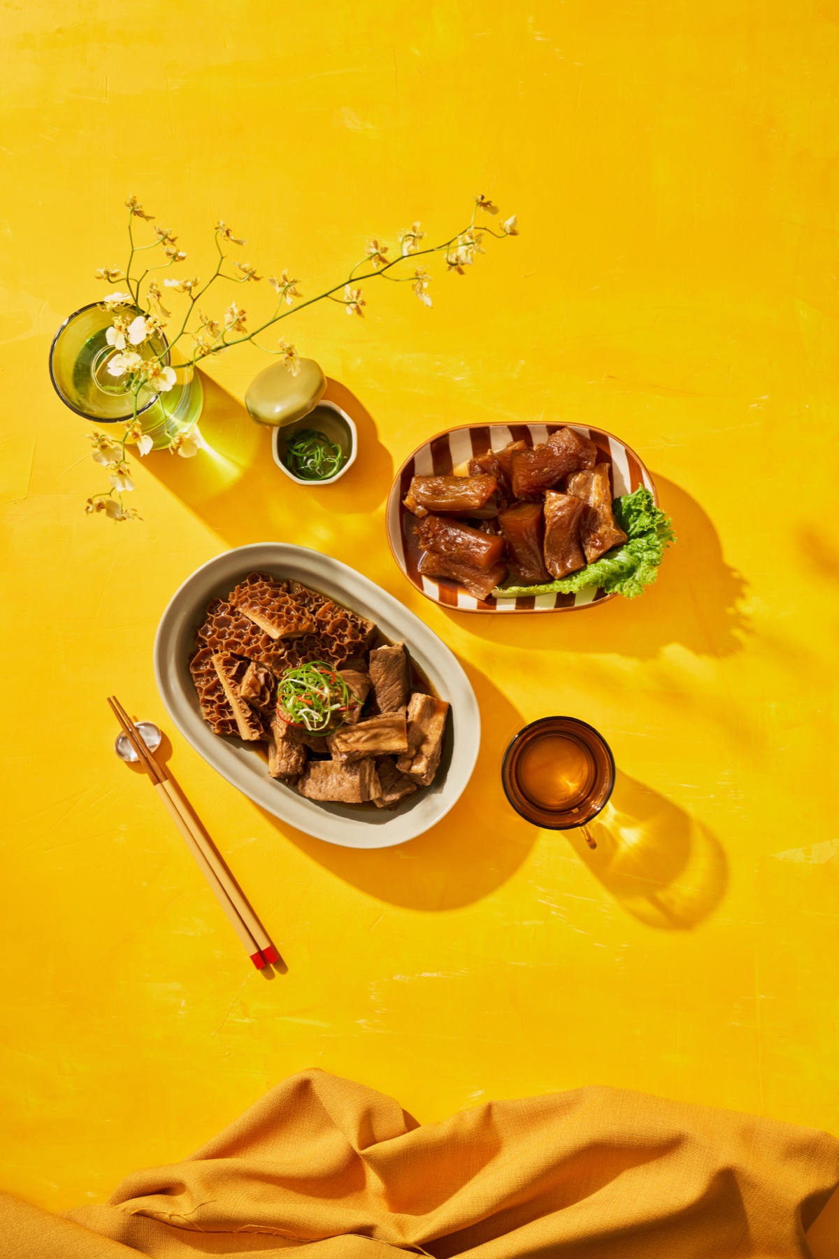 黃色背景上的滷肉、配菜與陶瓷盤